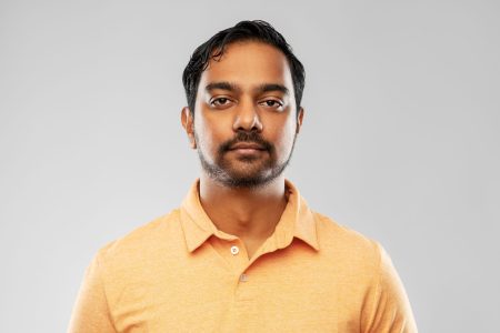 people and furniture concept - portrait of young indian man over grey background